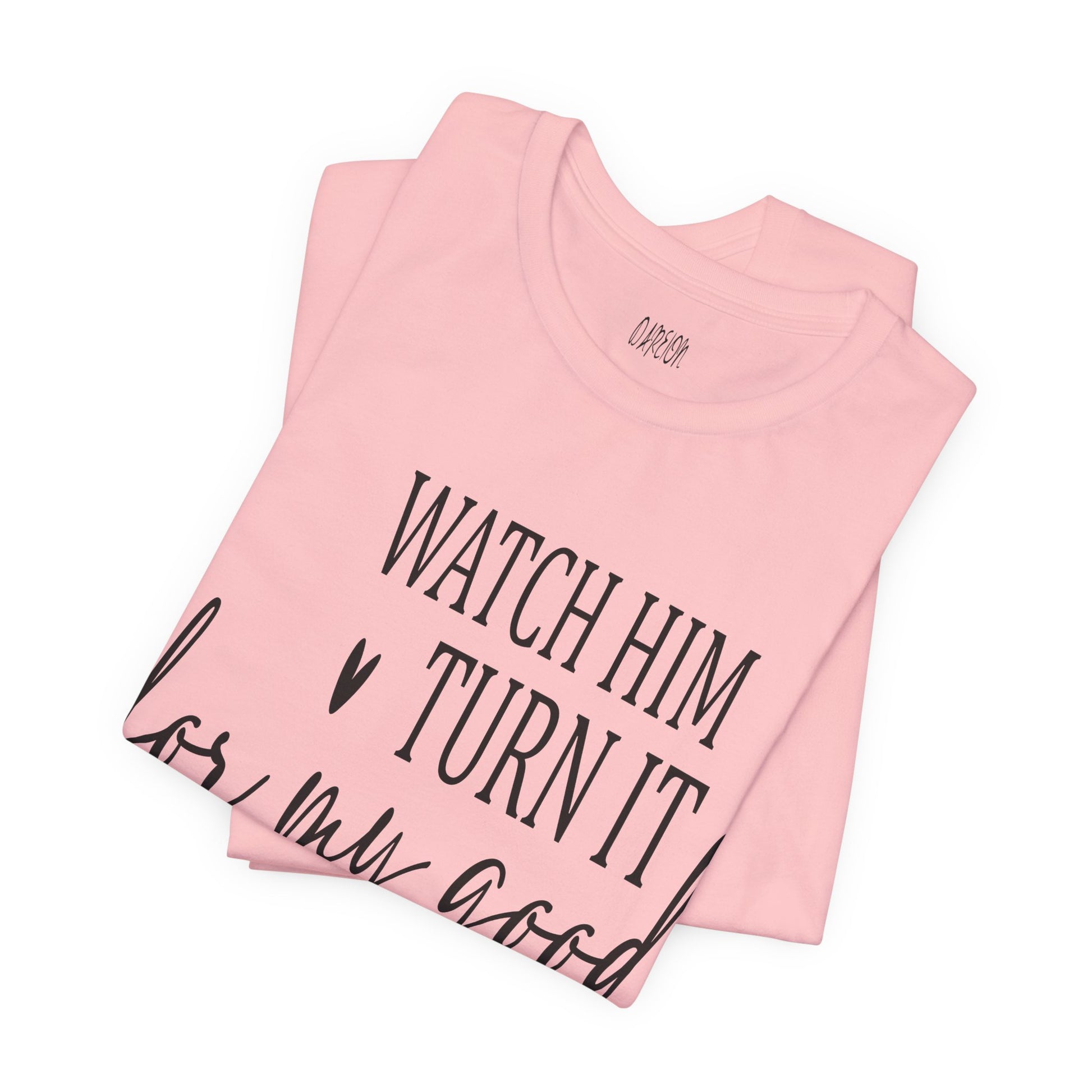 Pink t-shirt with text 'Watch him turn it into my good' on a white background