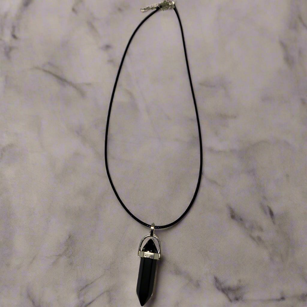 A black wax rope necklace with a silver chain and a teardrop-shaped crystal pendant.