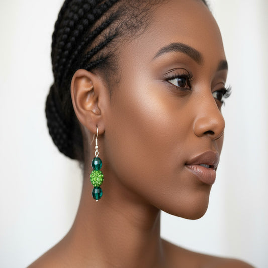 Woman wearing green earrings with a neutral background
