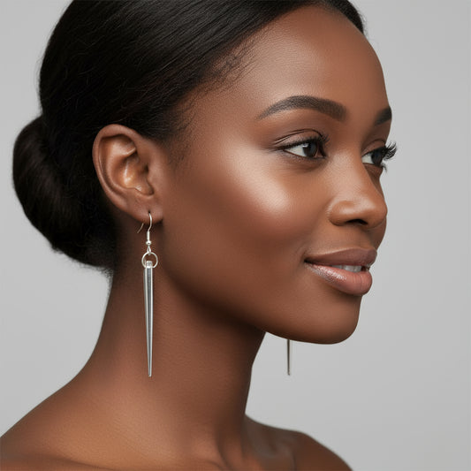 A pair of silver-colored spike earrings with a dangle design, displayed against a white background.