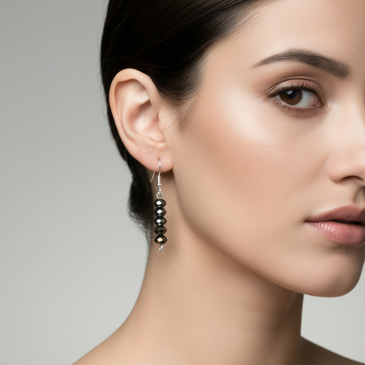 A pair of dangle earrings with a mix of black and brown jet beads, suspended from silver hooks.