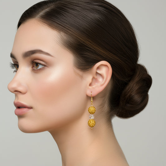 Gold-colored Shamballa rhinestone pave dangle earrings with clear beads, suspended from gold ear hooks.