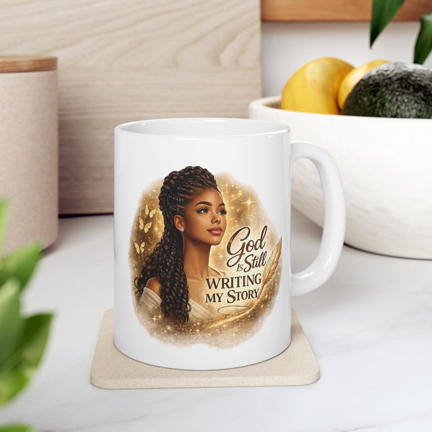White mug with a design of a woman and text 'God is Still Writing My Story' on a coaster.