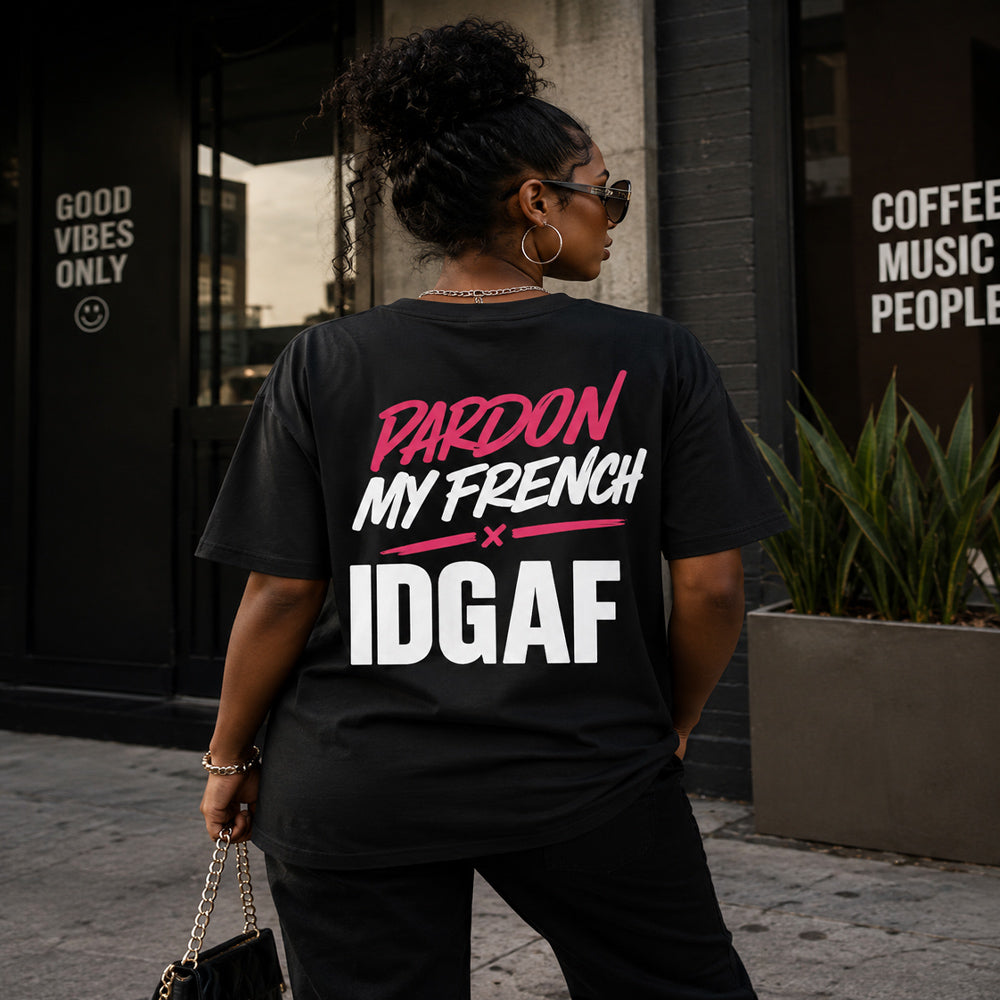 Person wearing a black t-shirt with pink and white text, standing outdoors.