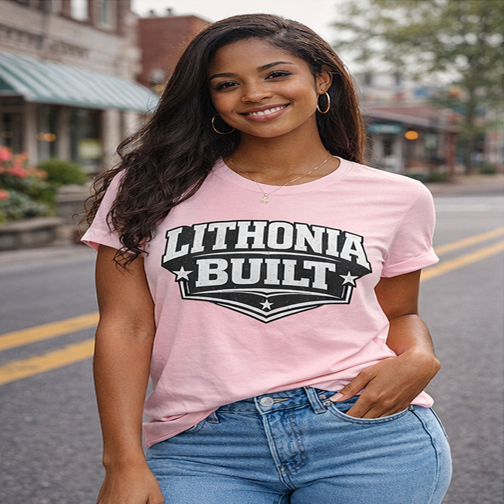 Woman wearing a pink 'Lithonia Built' t-shirt on a street.