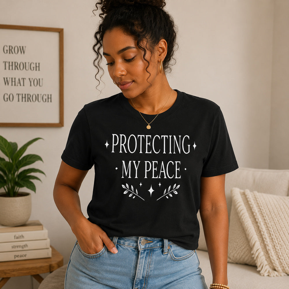 Woman wearing a black t-shirt with 'Protecting My Peace' text in a living room setting.